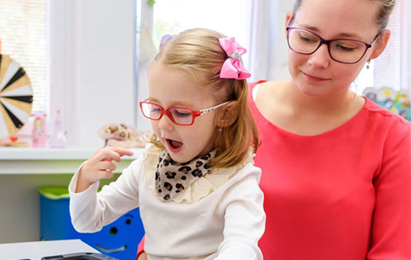 girl with special needs being assisted - Dogwood Pediatric Dentistry